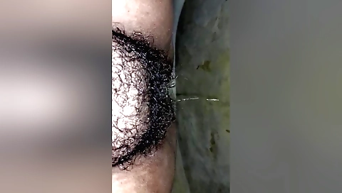 Girl pisses on her hairy pussy in amateur fetish video