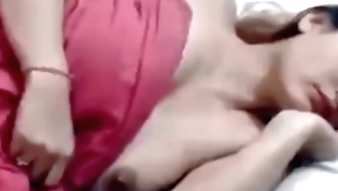 Sexy brunette in a white dress is standing and playing